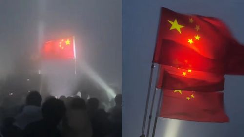 游客为举国旗夜爬男子照亮上山路